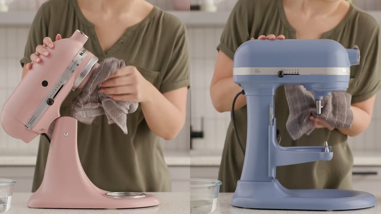 Kase kaldırma ve eğme başlığını silmek için bez kullanan kadın KitchenAid stand mikseri