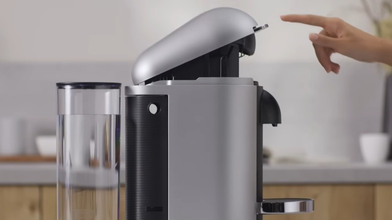 Nespresso kahve makinesini temizleyen kişi