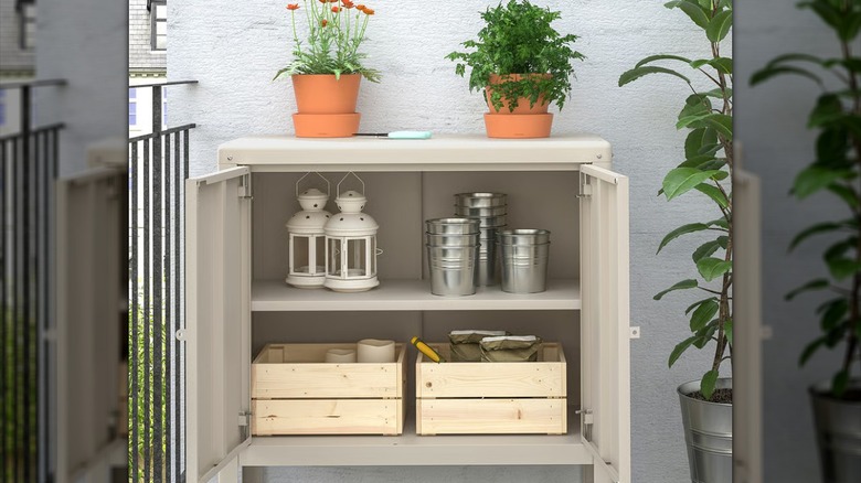 Bir IKEA KOLBJÖRN dolabı, verandada bahçe ve bahçe malzemelerini barındırır.