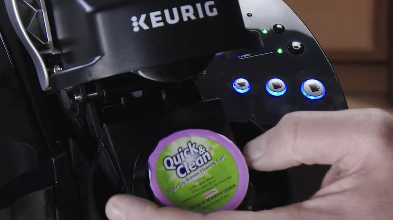 Hızlı ve Temiz K-Cup'ı kahve makinesine yerleştiren kişi