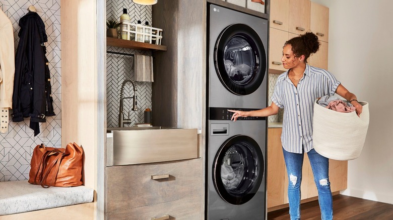 LG çamaşır makinesi ve kurutma ünitesinde çamaşır yıkayan kişi