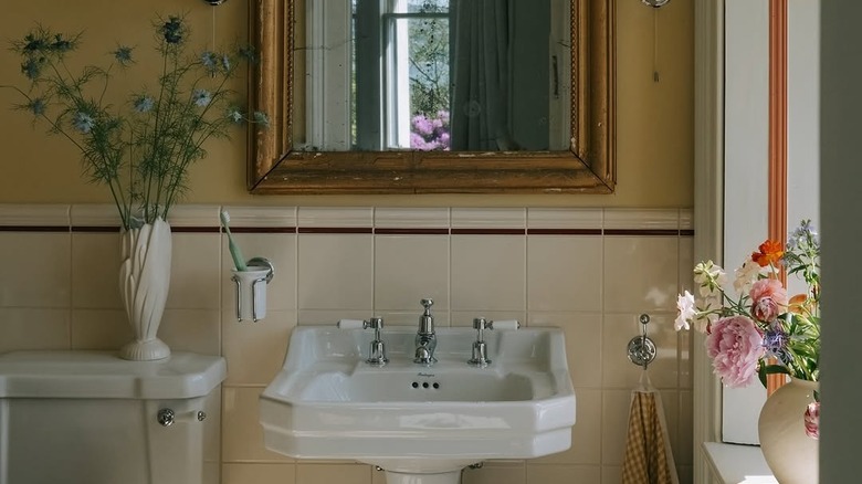 Krem rengi fayans backsplash ve kırmızı fayans bordürlü bir banyo