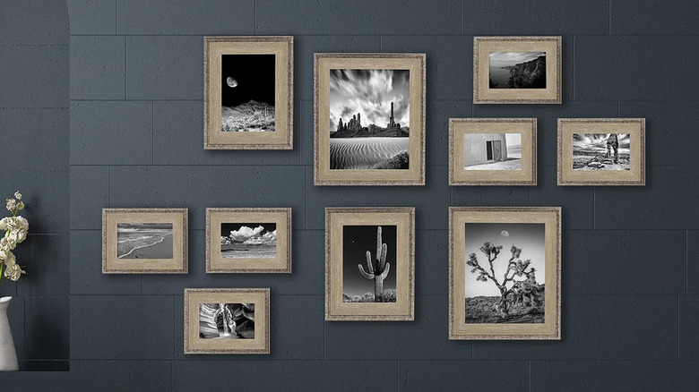 Gri bir duvarda siyah beyaz fotoğrafların sergilendiği 10 parçalı altın renkli resim çerçevesi seti