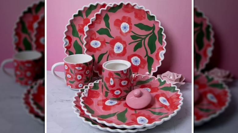 Arkasında pembe bir duvar bulunan mermer bir masanın üzerinde haşhaş tabağı ve fincan takımı duruyor.