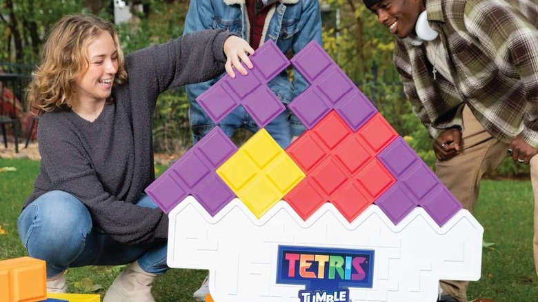 Arka bahçede açık havada gerçek hayattaki dev bir Tetris oyunu oynayan gençler.