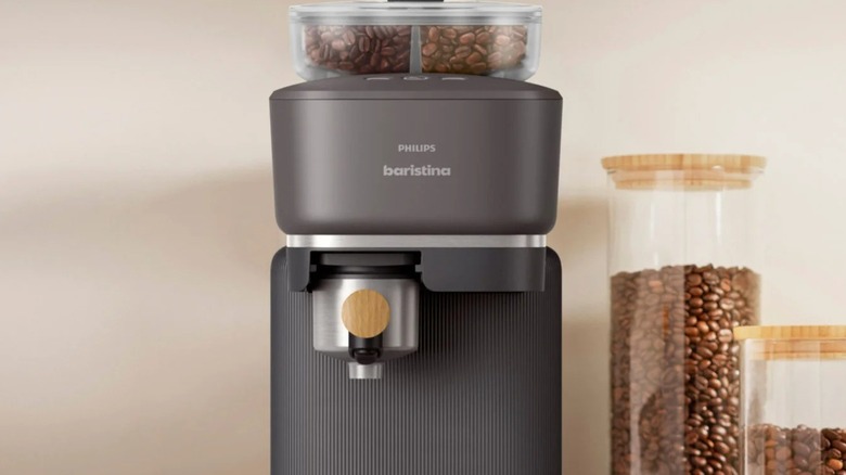Mutfakta birkaç kavanoz kahve çekirdeğinin yanında Philips Baristina Espresso Makinesi.