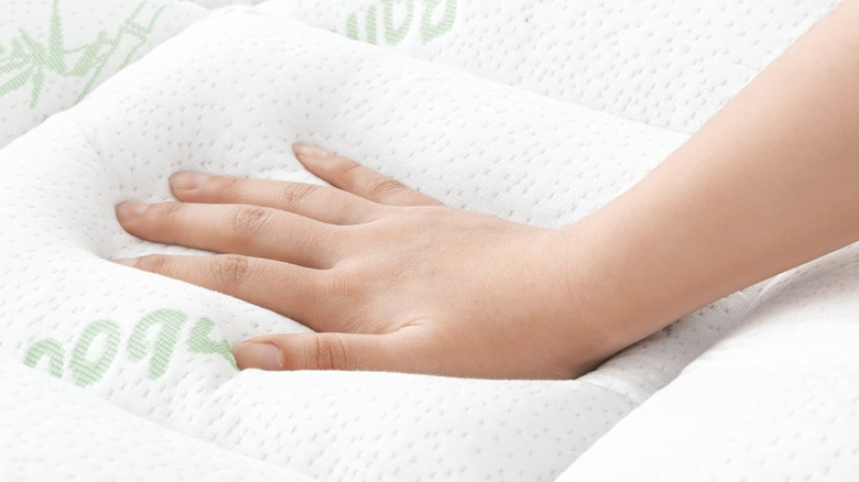 Üstüne elle bastırılan beyaz Niagara Sleep Solutions yatak koruyucusu