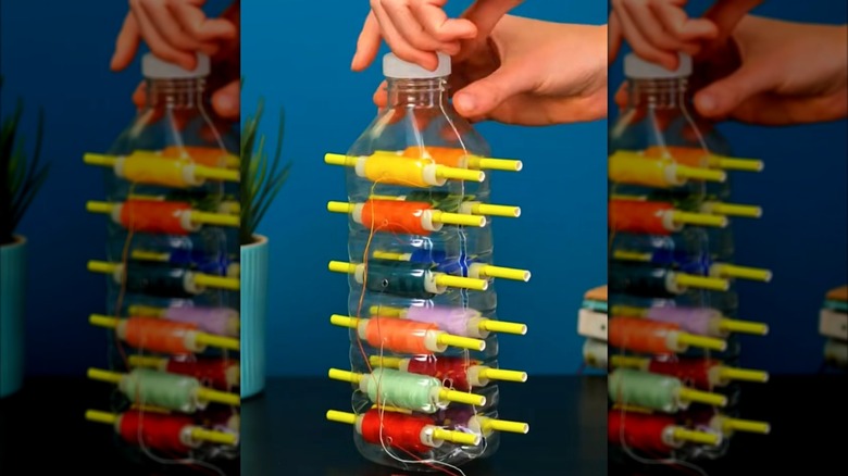 İplik dağıtıcısı olarak yeniden tasarlanmış plastik bir su şişesi.