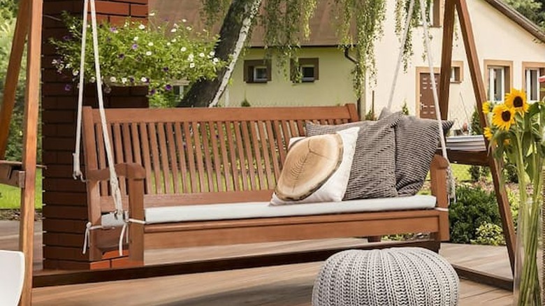 Verandada ahşap asılı sundurma salıncak