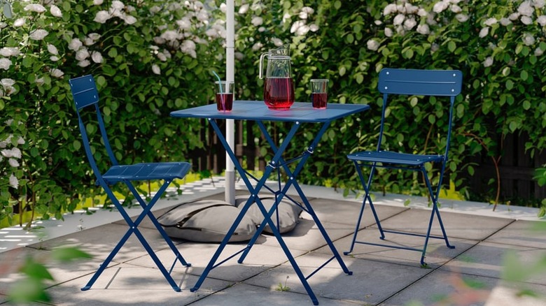 Avluda IKEA koyu mavi katlanır bistro masası ve sandalyeler