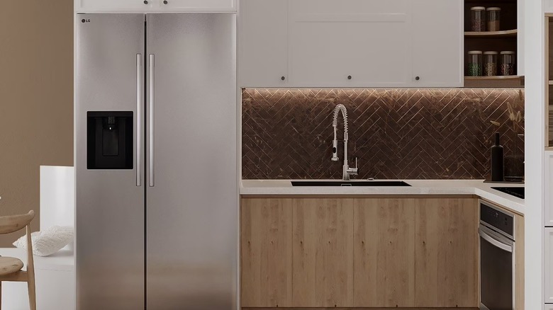 Balık sırtı backsplash ve ahşap dolaplara sahip modern bir mutfakta LG yan yana buzdolabı