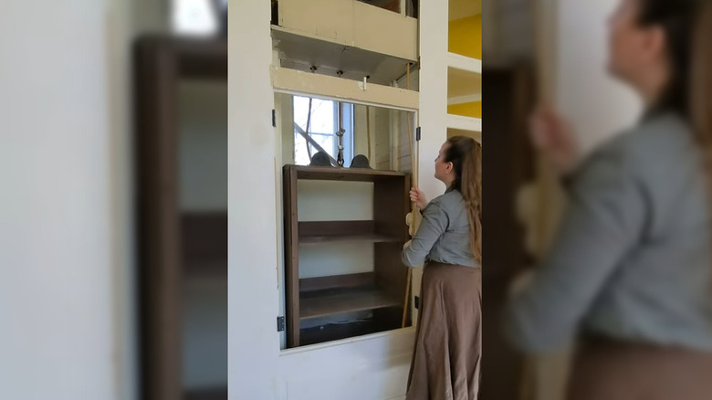 Antika servis asansörünü kaldıran kişi