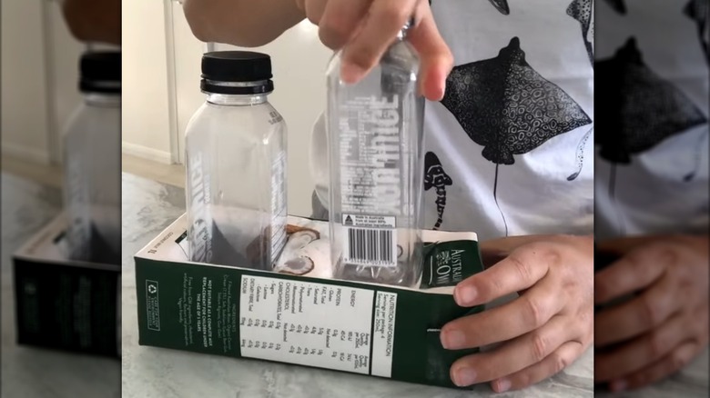 Süt kartonu tutucusuna küçük plastik şişeler yerleştiren eller