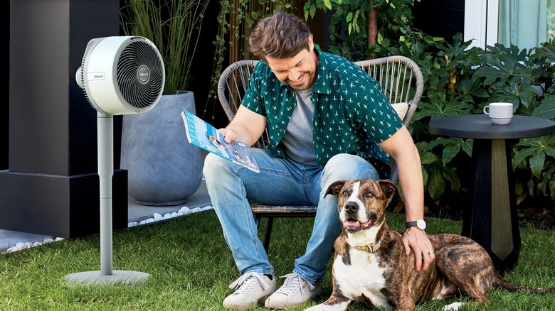 Shark FlexBreeze Kablosuz Vantilatörle dışarıda oturan adam ve köpek