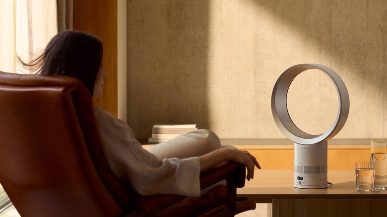 Masanın üzerinde Dyson Cool CF1 Bladeless Fan ile sandalyede oturan bir kadın