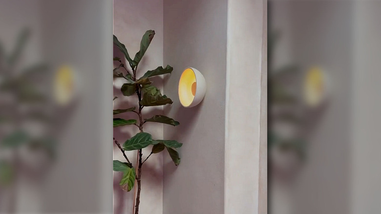 Bir DIYer, IKEA kasesi, disk ışığı, sprey boya ve diğer malzemelerle aplik yapıyor