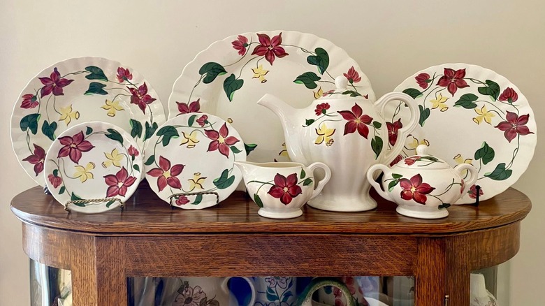 Çiçekli Blue Ridge Pottery tabaklarının yanı sıra bir sürahi, sos kabı ve şekerlik, tümü bir bölmenin üzerinde sergileniyor