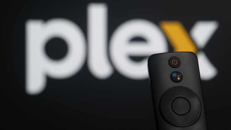 Uzaktan kumandalı bir TV'deki Plex logosunun hafif bulanık görüntüsü