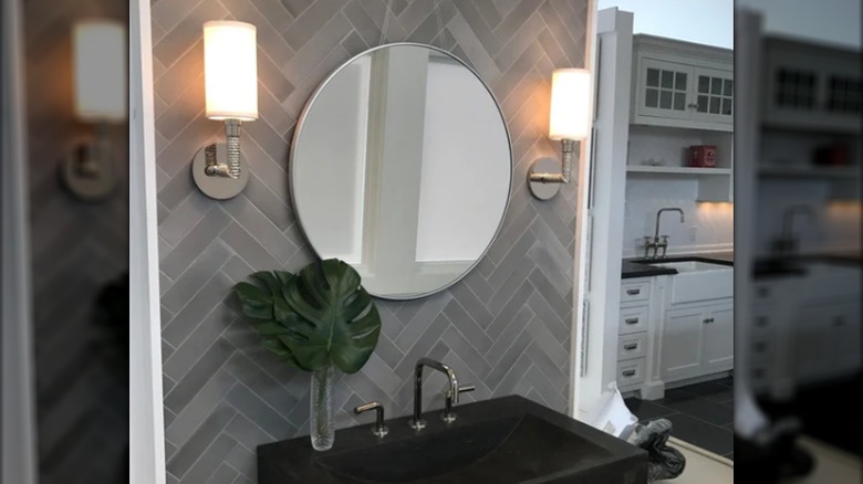 Balıksırtı desenli, dişbudak çimento fayanslarından yapılmış bir lavabonun, aynanın ve aydınlatmanın arkasındaki backsplash