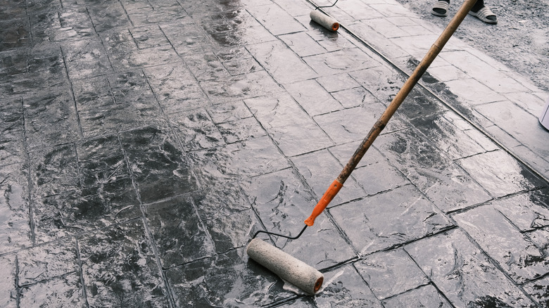 mühürleyici uygulayan bir boya rulosu ile damgalanmış beton