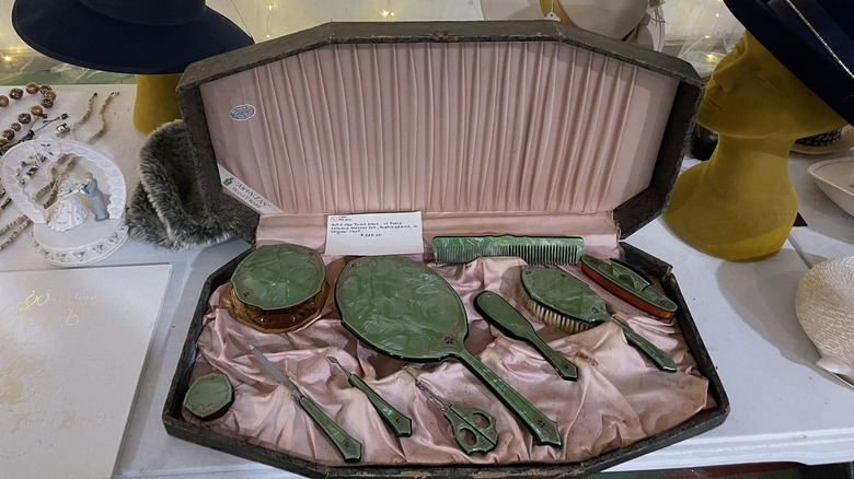 Pembe saten iç kısmı ve yeşil selüloit güzellik aksesuarlarıyla 1930'lardan veya 1940'lardan kalma vintage bir makyaj kutusu.