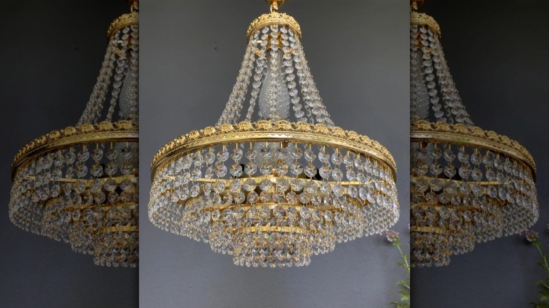 Gri boyalı duvarları olan bir odada 1960'lardan kalma vintage bir Swarovski avize asılı.