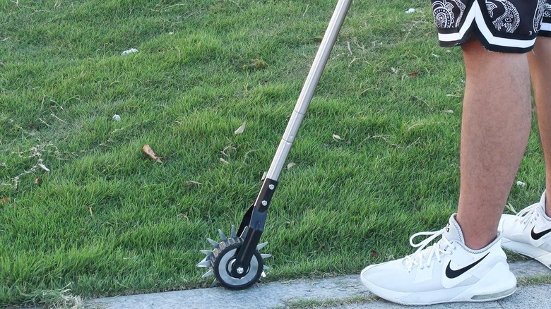 Amazon'da bulunan Baraystus Döner Kenar Düzeltme Aracı, beyaz ayakkabı giyen bir adam tarafından kullanılıyor