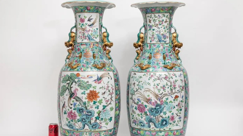 Bir kutu Coca Cola'nın yanında foo köpek saplı Qing hanedanına ait Famille Rose vazoları