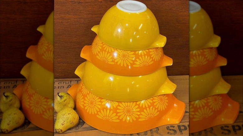 Üst üste baş aşağı istiflenmiş turuncu ve sarı renkli Pyrex karıştırma kaseleri seti.