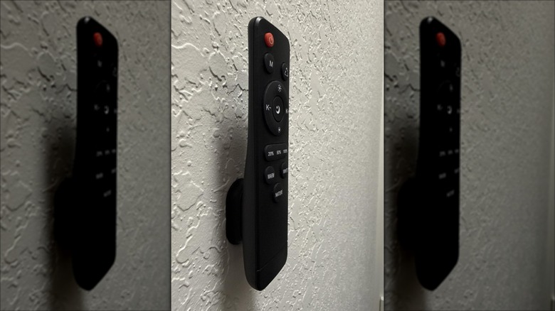 Manyetik tutucu kullanılarak duvara monte edilmiş siyah TV uzaktan kumandası