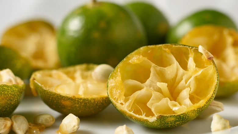Beyaz bir tezgahın üzerinde tohumları olan, suyu sıkılmış ve eski yarım limonlar.