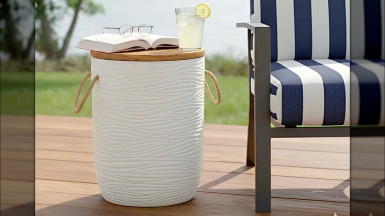 Üzerine bir bardak limonata, bir kitap ve bardakların yerleştirildiği Stylecraft dış mekan saklama masası