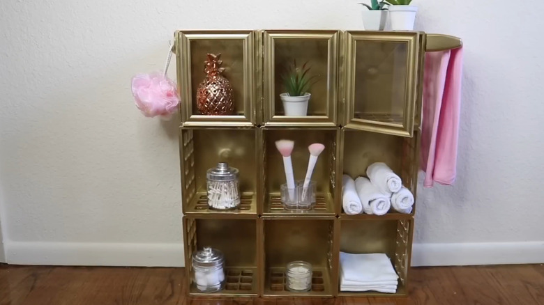 Altın boyalı mini plastik kasalardan yapılmış bir DIY banyo dolabının son tasarımı.