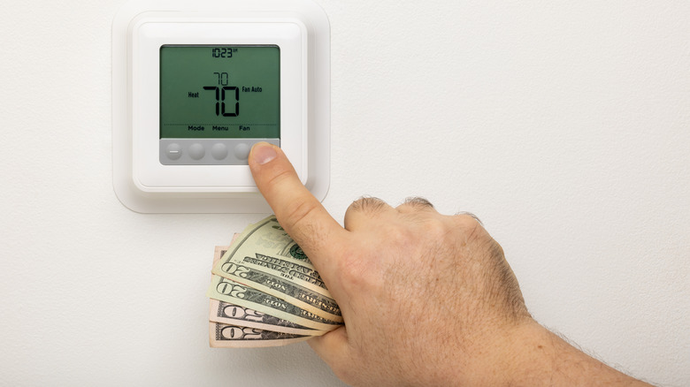 Parayı ayarlayan termostatı tutan el