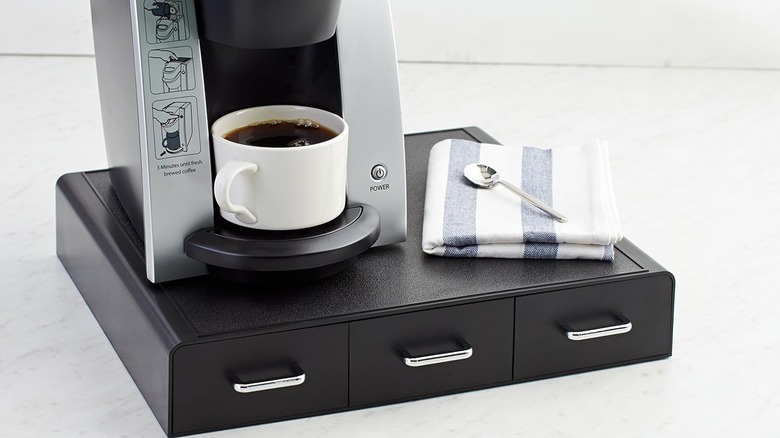Amazon Basics K-Cup Uyumlu Kahve Kapsülü Saklama Çekmecesi, kahve makinesi ve üstünde peçete ve kaşık
