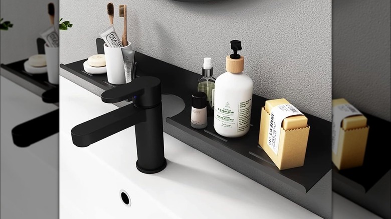 Banyo lavabosunun arkasındaki duvara monte edilen ve banyo malzemelerini saklamak için kullanılan, duvara monte dar bir raf.