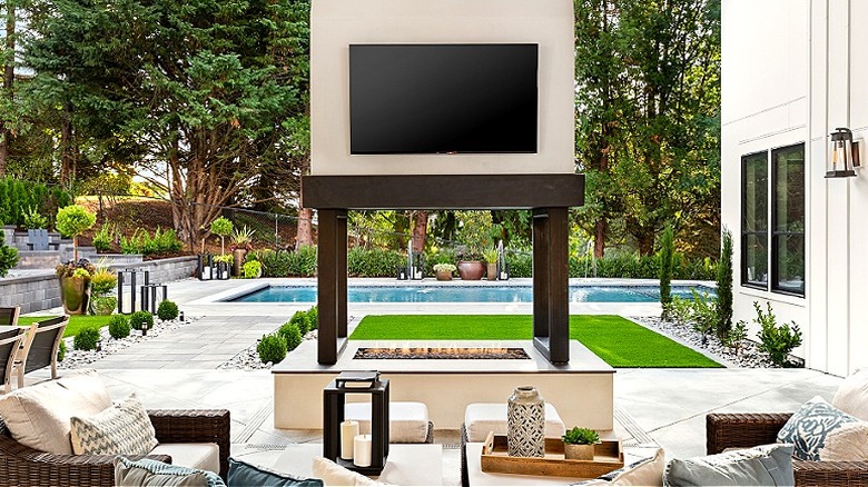 Havuzun önündeki açık hava ateş çukurunun üzerinde bir TV