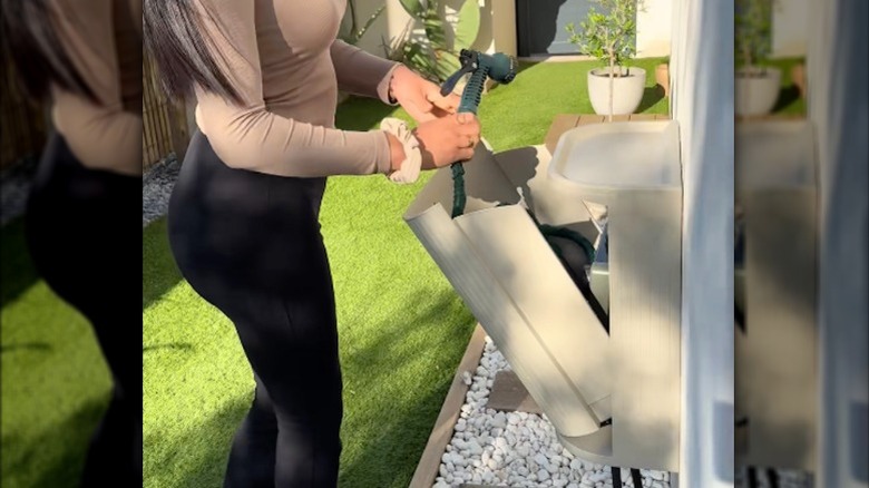 IKEA'nın GÅRDSBUTIK çöp kutusundan yapılmış kullanışlı bir hortum saklama kutusu