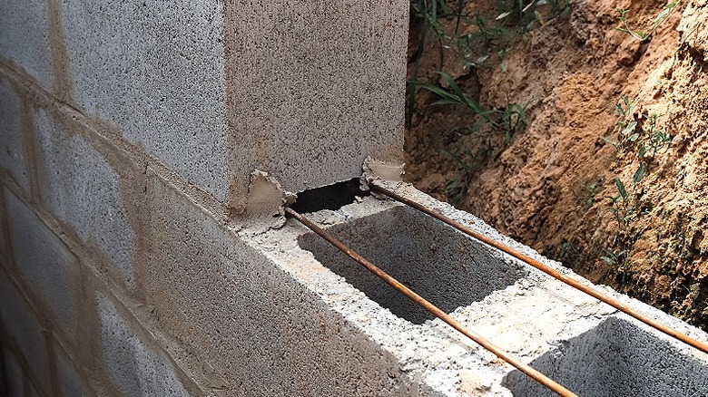 Katmanlar arasında inşaat demiri ile birbirine yapıştırılmış yığılmış beton bloklar