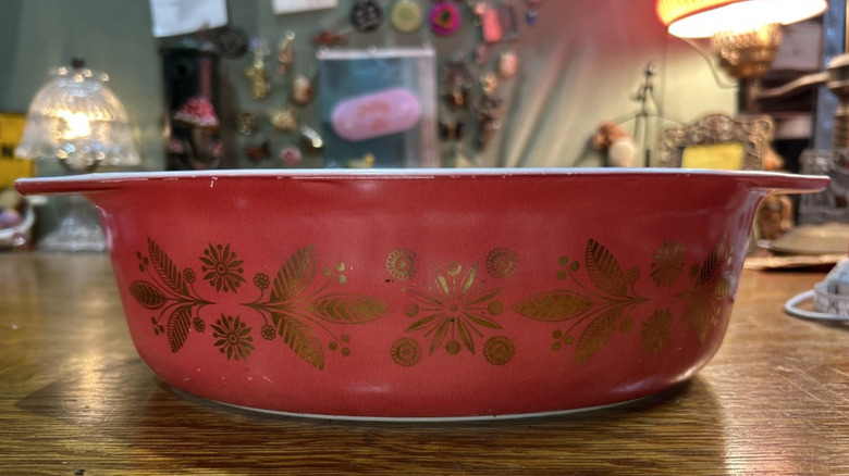 Altın Poinsettia olarak bilinen kırmızı Pyrex güveç tabağı üzerinde altın