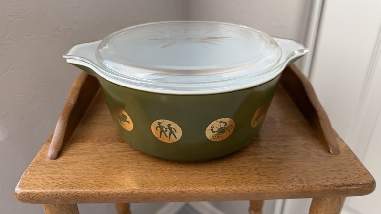 Nadir bir Pyrex zodyak tabağı küçük bir ahşap sergi masasının üzerinde duruyor