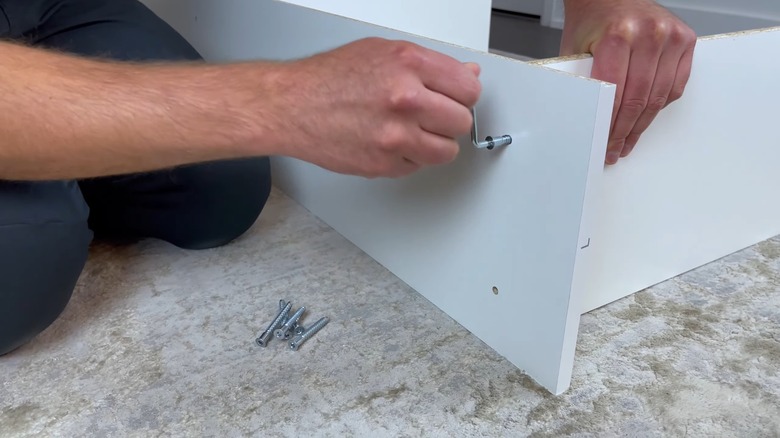 IKEA GERSBY kitaplığını birbirine vidalayan adam