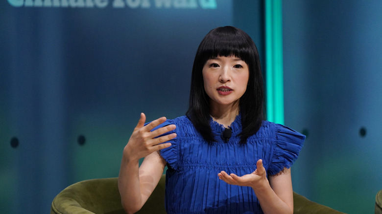 Marie Kondo mavi gömlekli bir panelde konuşuyor