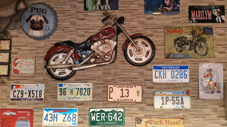Vintage plakalar, motosiklet çıkartmaları ve posterlerle dolu kolaj duvarı