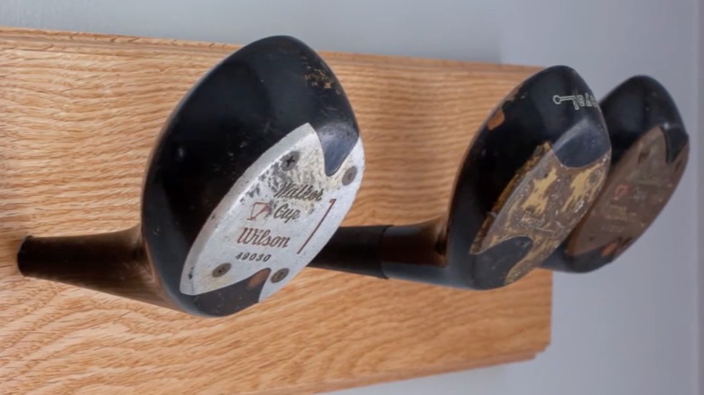 Havlu askısı veya portmanto oluşturmak için ahşap bir tahtaya bağlanan üç golf sopası kafası
