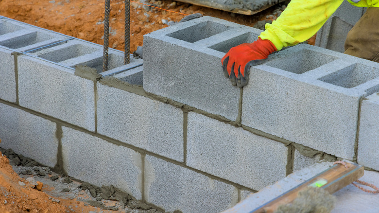 Kişi beton bloklarla duvar inşa ediyor