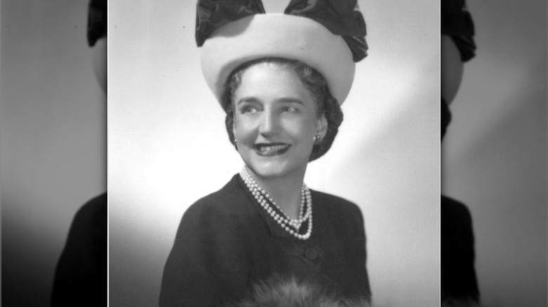 Dorothy Draper siyah bir elbise ve fiyonklu şapkasıyla kameraya gülümsüyor.
