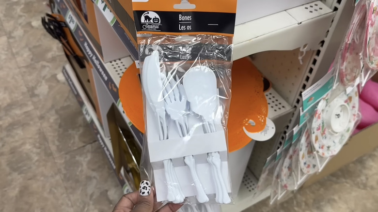 Dollar Tree mağazasındaki bir raftan sarkan, kemik şeklinde 12'li beyaz bıçak, çatal ve kaşık paketi