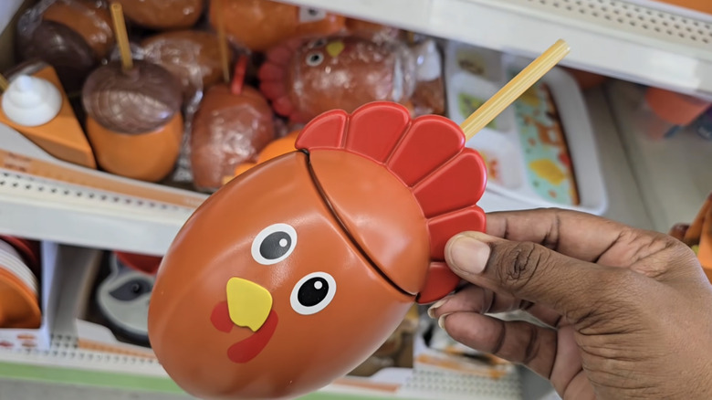 Dollar Tree mağazasında hindiye benzeyen bir fincan tutan bir kişi
