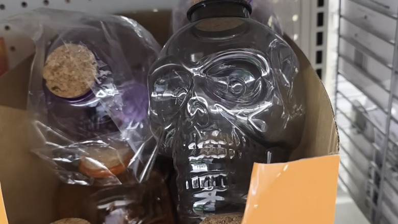 Dollar Tree mağazasında rafta duran, üstü mantar kaplı, kafatası şeklinde plastik bir şişe